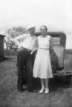 A couple leaning on a car by Basil Clemons 1887-1964