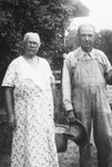 A couple in front of a house by Basil Clemons 1887-1964