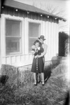 A couple in front of a house by Basil Clemons 1887-1964