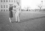 A couple in front of a building by Basil Clemons 1887-1964