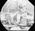 A couple sitting on a car by Basil Clemons 1887-1964