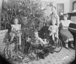 A mother and father with three children pose in front of a Christmas tree by Basil Clemons 1887-1964