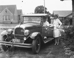 A man and woman beside an automobile photographed in a residential area, Breckenridge, Texas by Basil Clemons 1887-1964