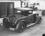 Shiny new auto truck with wooden cargo bed parked beside a house, Breckenridge, Texas by Basil Clemons 1887-1964