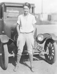 A teenage boy stands in front of a truck by Basil Clemons 1887-1964