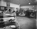 Chevrolet dealership showroom with salesmen standing near cars by Basil Clemons 1887-1964