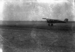 Airplane ready to take off from a grassy field by Basil Clemons 1887-1964