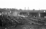 People standing on a bridge overlooking a pile of unidentified debris by Basil Clemons 1887-1964