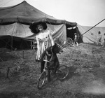 Circus performer and a bear cub on a bike by Basil Clemons 1887-1964