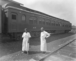 An African American woman and man standing fron of the "John Robinson's Circus" train by Basil Clemons 1887-1964