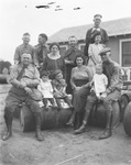 A group of men, women and children sitting on barrels by Basil Clemons 1887-1964