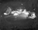 Night photograph of a lighted garden and yard beside a residential home, Breckenridge, Texas by Basil Clemons 1887-1964