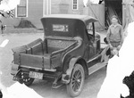 A man standing next to a truck by Basil Clemons 1887-1964