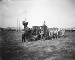 At the circus grounds, team of horses pulls a wagon with a large digger instrument for placing the tent poles, Breckenridge, Texas by Basil Clemons 1887-1964