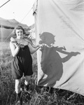 Female circus performer holds a large snake around her neck next to a circus tent, Breckenridge, Texas by Basil Clemons 1887-1964