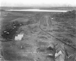 Aerial view of Lake Grand with tents, wagons, and horses in the foreground, near oil fields in Breckenridge, Texas; photographed from the "Man-O-War" by Basil Clemons 1887-1964