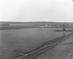 McCluskey oil field near Breckenridge, Texas; flat landscape with oil derricks in background by Basil Clemons 1887-1964