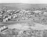 Aerial view of a small community with structures and tents including an oil derrick among the buildings; South Bend, Texas by Basil Clemons 1887-1964