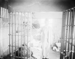 Unidentified man stands in jail cell with opened door, Breckenridge, Texas by Basil Clemons 1887-1964