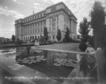 Stephens County Courthouse with people enjoying the lilly pond, Breckenridge, Texas by Basil Clemons 1887-1964