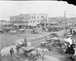 Downtown Breckenridge, Texas, with dirt streets crowded with cars and horse drawn wagons; buildings include Sager Hotel, Alhambra and National theaters, Gladys Hotel, and Owl Drugstore by Basil Clemons 1887-1964