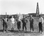 C.W.C. Drilling Co.; four men and a woman stand next to an oil field with derricks and small wooden buildings, near Breckenridge, Texass by Basil Clemons 1887-1964