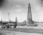 "The Oil Field," an oil field with work trucks on the road and oil derricks across the landscapes by Basil Clemons 1887-1964