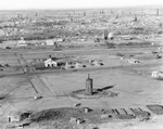 Air view of oil field with derricks and tanks scattered among town settlement, Breckenridge, Texas by Basil Clemons 1887-1964