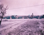 Oil field machinery and trucks lined up on road near Breckenridge (the town is in the background) by Basil Clemons 1887-1964