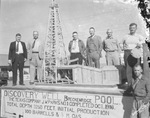 Men stand on platform with model of oil derrick; sign reads in part: Discovery Well, Breckenridge Pool, The Texas Co., J.W. Parks No. 1, completed October 1916 by Basil Clemons 1887-1964