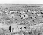 Air view of a settlement of wooden buildings and houses at an oil field by Basil Clemons 1887-1964