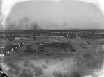 Air view of oil field in distance with a row of small houses and railroad tracks nearby, Breckenridge, Texas by Basil Clemons 1887-1964