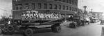 Parade with flatbed trucks filled with young women in downtown Breckenridge, Texas by Basil Clemons 1887-1964