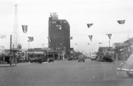 Flags are strung across the main street of Breckenridge, Texas with the Burch Hotel in the background by Basil Clemons 1887-1964