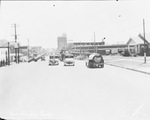 Cars and trucks driving through downtown Breckenridge, Texas by Basil Clemons 1887-1964