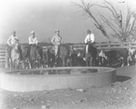 Four men on horseback in front of a water tank with a small herd of cattle behind them on an unidentified ranch in Stephens County, Texas by Basil Clemons 1887-1964