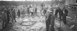 Men and young boys watch rattlesnakes slithering on the ground following the Texas Rattlesnake Hunt near Breckenridge, Texas by Basil Clemons 1887-1964