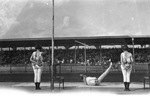 Three circus performers on a platform before a large crowd sitting under covered bleachers, Breckenridge, Texas by Basil Clemons 1887-1964