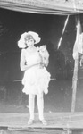 A young female circus performer dressed in ruffled costume holds a monkey in her arms, Breckenridge, Texas by Basil Clemons 1887-1964