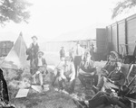 Circus performers and workers relax on folding chairs outside a circus tent, Breckenridge, Texas by Basil Clemons 1887-1964