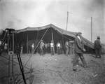 Men working to insert poles to lift up a large circus tent, Breckenridge, Texas by Basil Clemons 1887-1964