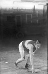 A runner posing in runner's stance with oil derricks in background by Basil Clemons