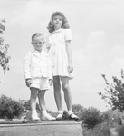 Young boy and girl, both wearing all white clothing by Basil Clemons 1887-1964