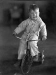 Young boy riding a tricycle by Basil Clemons 1887-1964