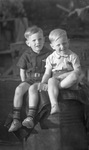 Two young boys sitting on a large metal container by Basil Clemons 1887-1964