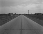 Empty road with houses and businesses in background (undated) by Bill Wood Photo Company