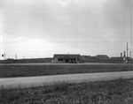 Dirt road with small house and car in the distance (undated) by Bill Wood Photo Company