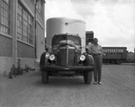 Front view of truck and trailer with man leaning on hood (undated) by Bill Wood Photo Company