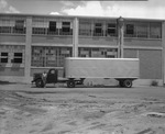 Transport truck parked outside of warehouse by Bill Wood Photo Company