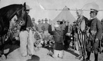 Enactment: actual World War I soldiers with man dressed in Uncle Sam costume and soldier beside a horse and captured enemy on his knees